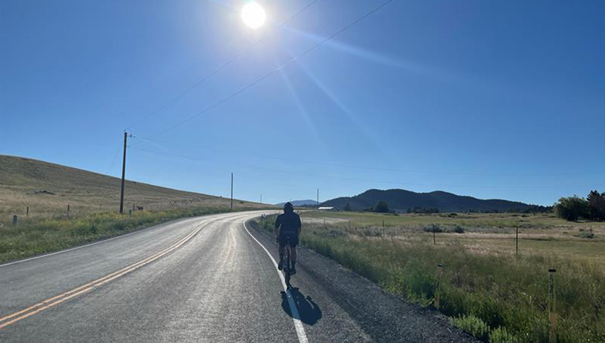 Bicyclist traveling on a Montana highway during the summer