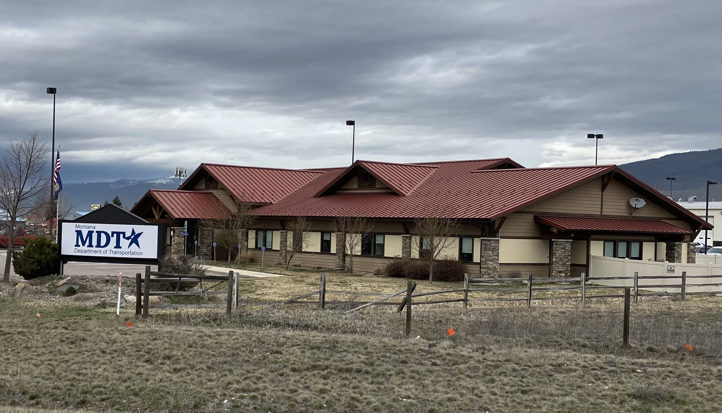 Image of an office building with a red roof and the sign in front states Montana Department of Transportation - MDT